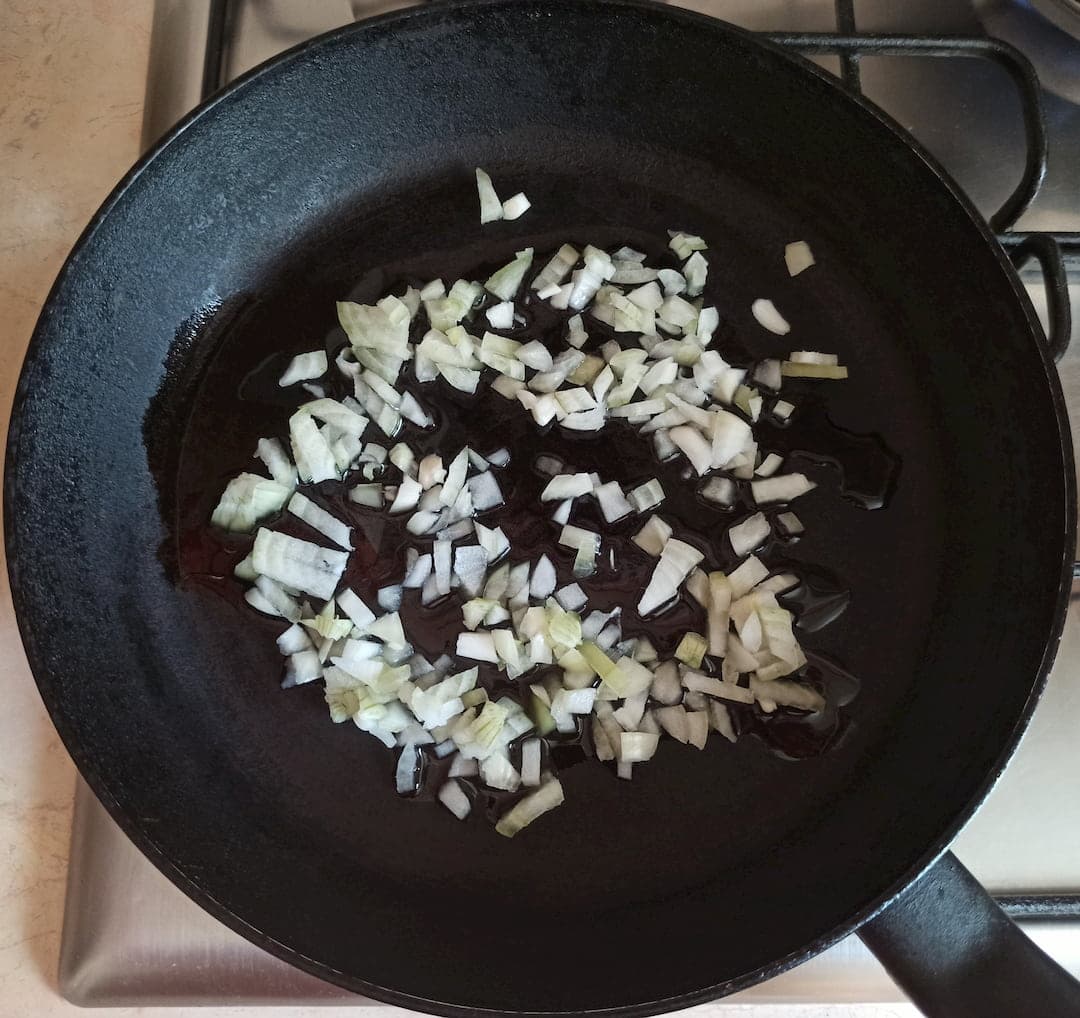 Лук жарится на сковороде